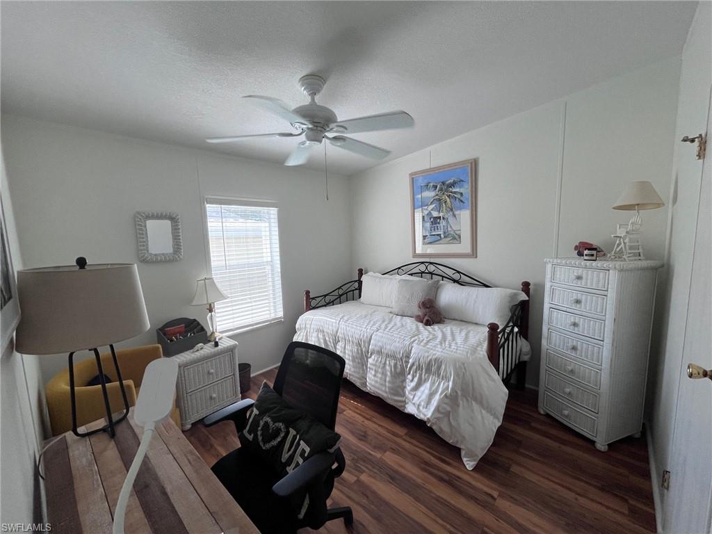 65 Turquoise Avenue, Unit 65T Naples, FL 34114 - Photo 25 of 34 a bedroom with a bed and wooden floor