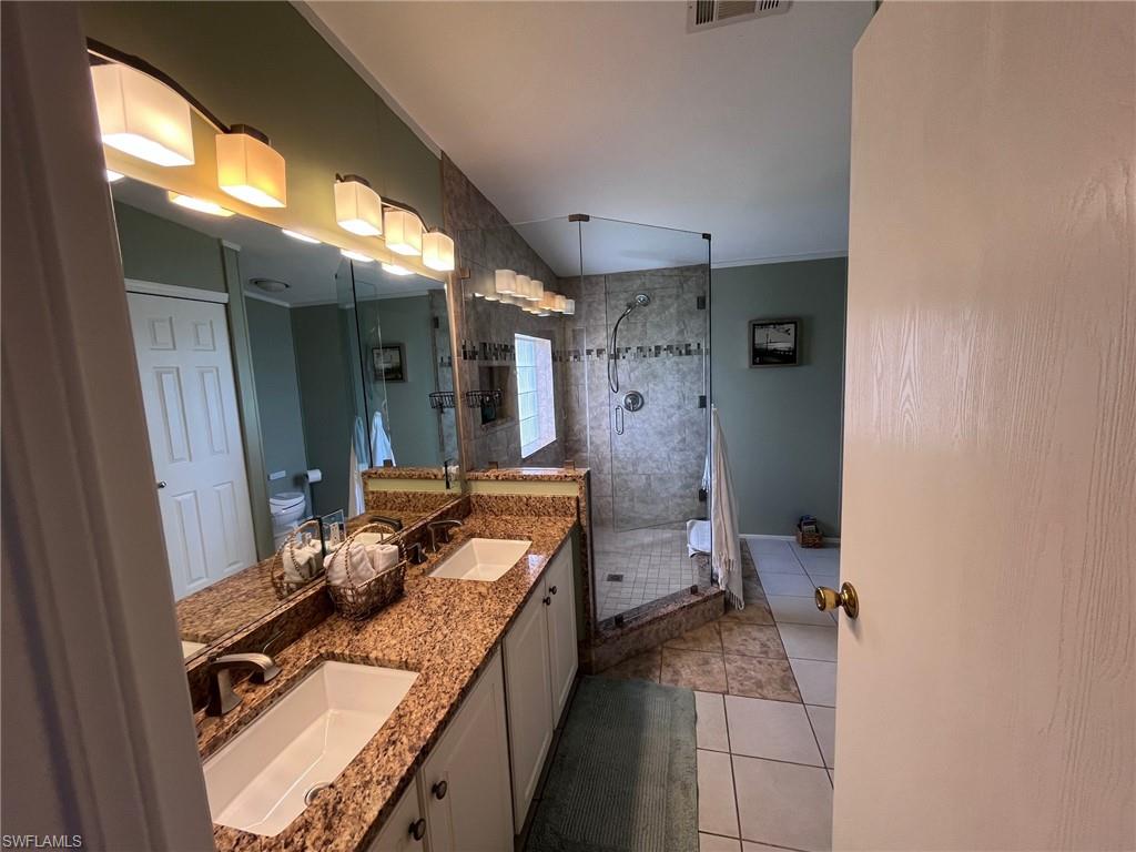 65 Turquoise Avenue, Unit 65T Naples, FL 34114 - Photo 30 of 34 a bathroom with a granite countertop sink mirror vanity and toilet