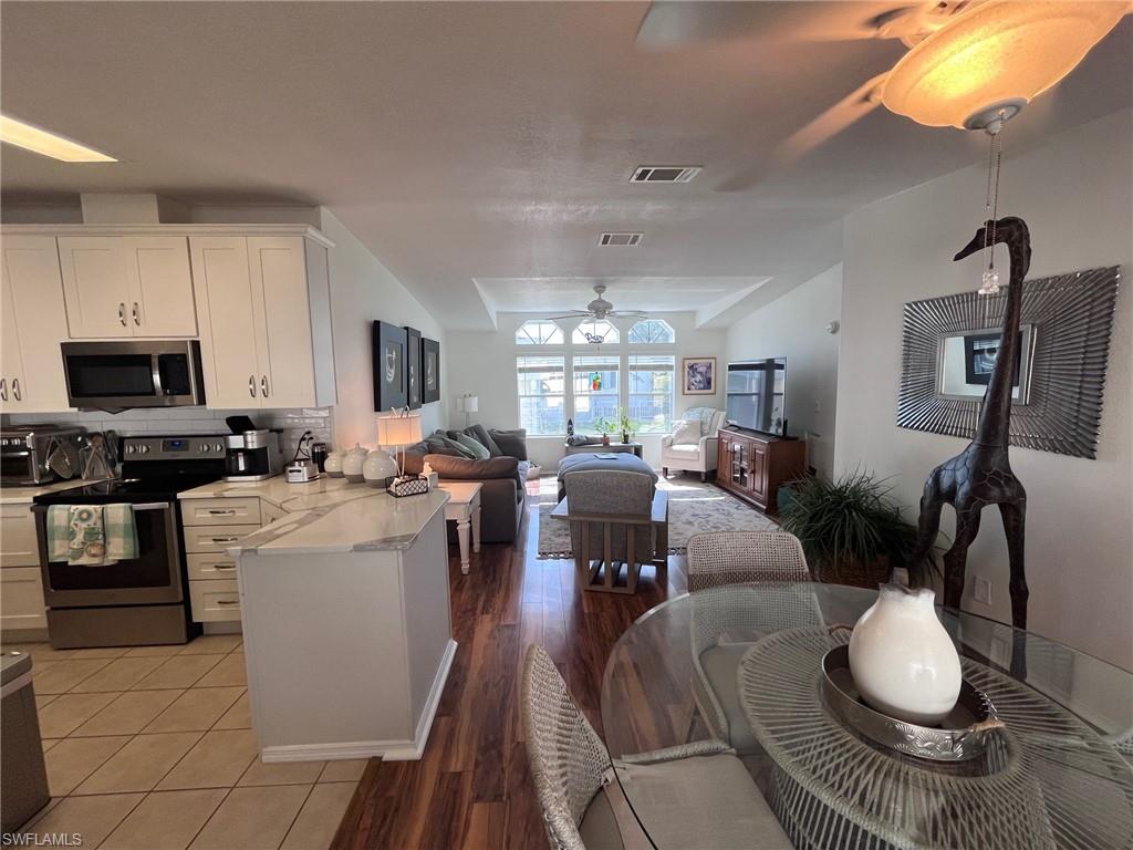 65 Turquoise Avenue, Unit 65T Naples, FL 34114 - Photo 10 of 34 a living room with furniture a flat screen tv and kitchen view