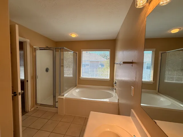 an empty room with window and chandelier fan