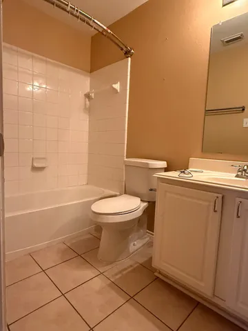 an empty room with a window and chandelier fan
