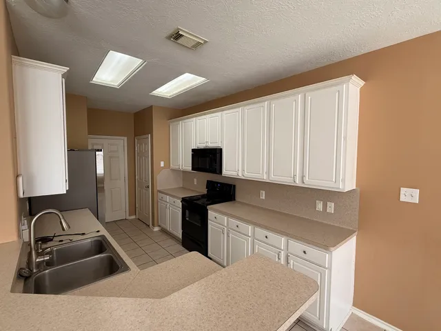 a kitchen with a sink cabinets and refrigerator