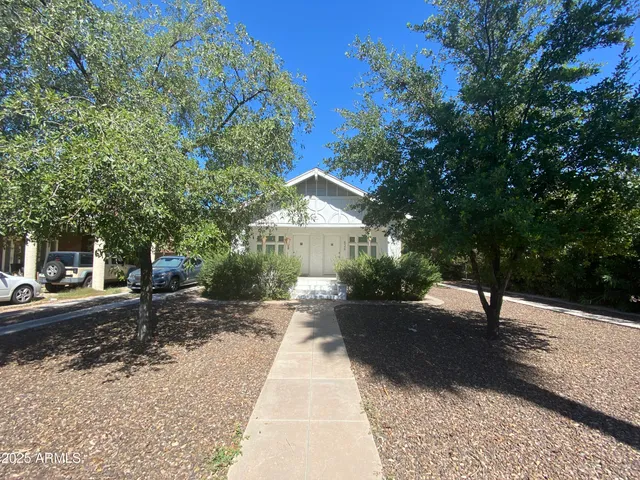 a view of a street with a bench and trees around
