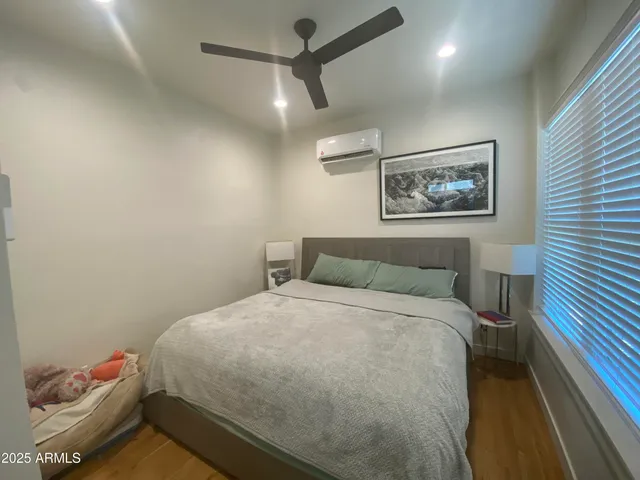 a bedroom with a bed and a painting on the wall