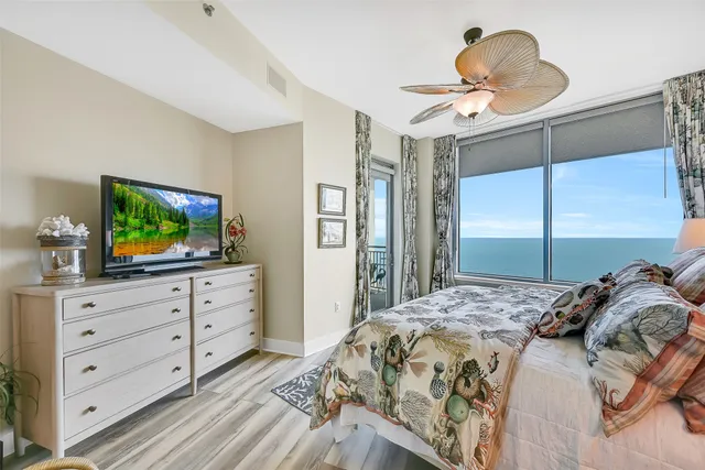 a bathroom with a granite countertop sink a toilet a mirror and shower