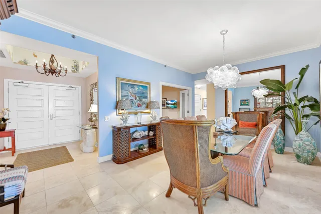 a dining room with furniture a chandelier and window