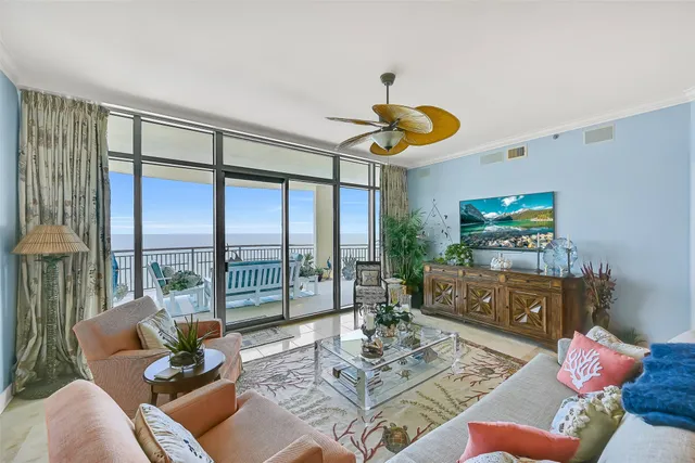 a living room with furniture and a floor to ceiling window