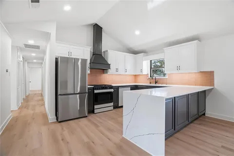 a kitchen with stainless steel appliances a refrigerator and a stove top oven