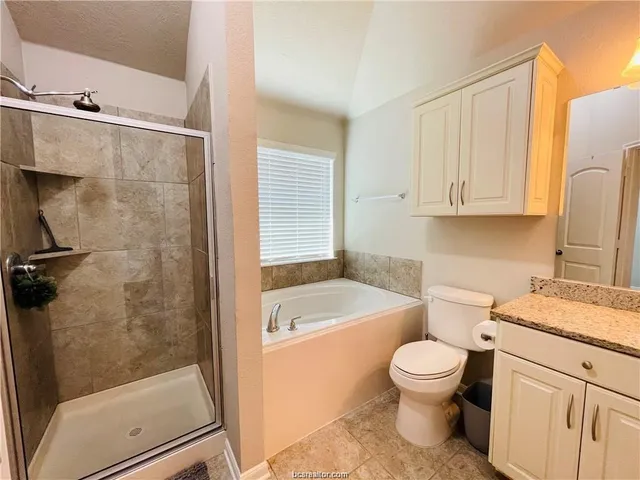 a bathroom with a granite countertop toilet a sink and bathtub