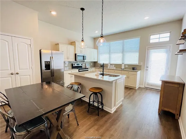 a kitchen with a table chairs stove and microwave