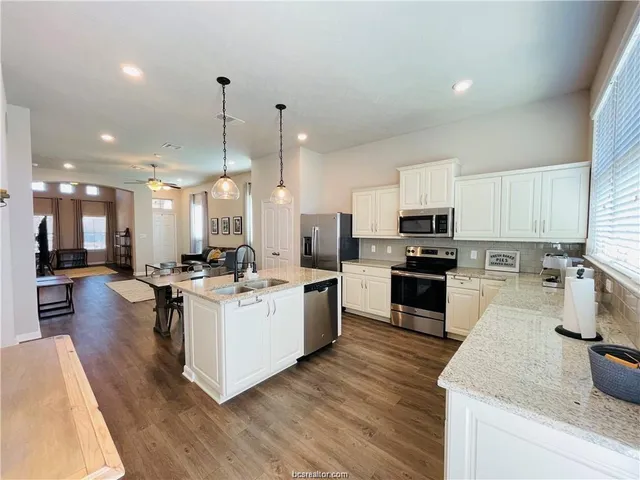 a kitchen with a sink stove and wooden floor