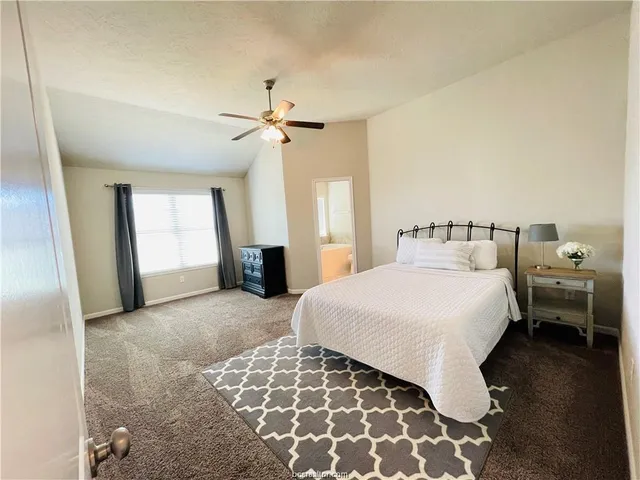 a spacious bedroom with a bed and a chandelier