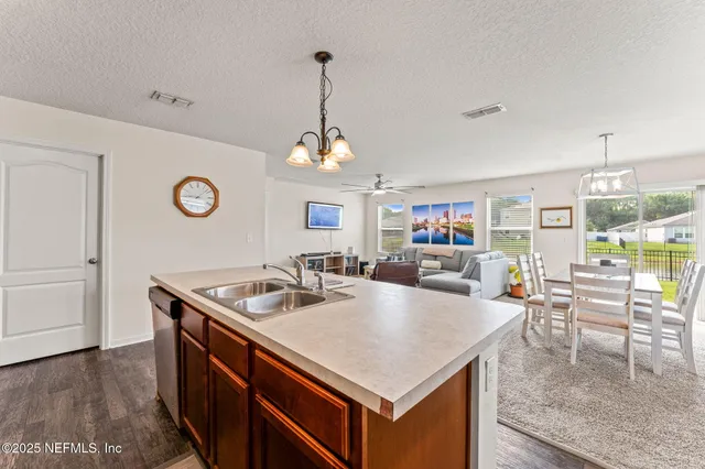 a kitchen with stainless steel appliances granite countertop a sink a stove and a wooden floors