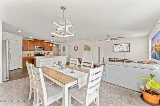a view of a dining room with furniture and chandelier