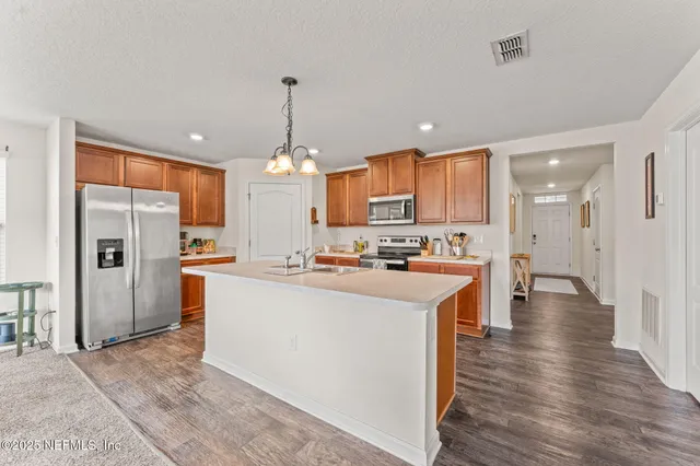 a large kitchen with cabinets and stainless steel appliances