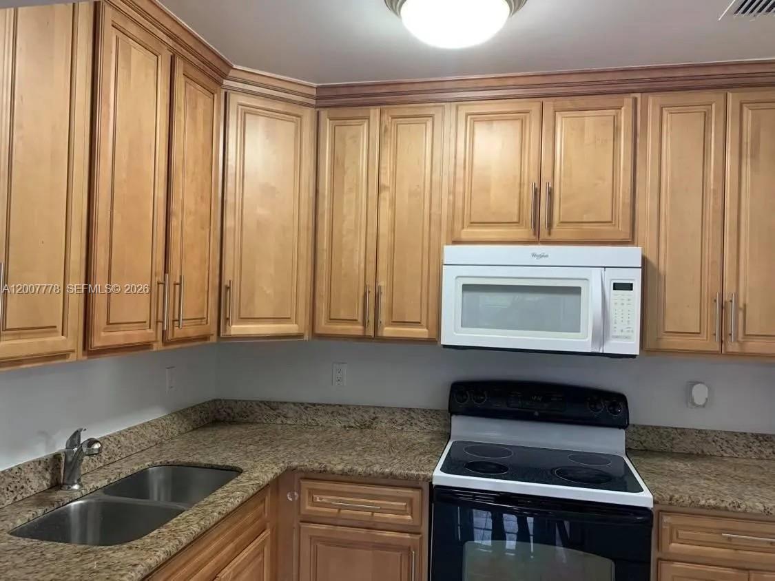 4289 Northwest 5th Street Miami, FL 33126 - Photo 8 of 29 a kitchen with granite countertop a sink a stove and cabinets