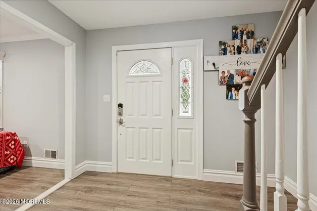 a view of a hallway with wooden floor and closet