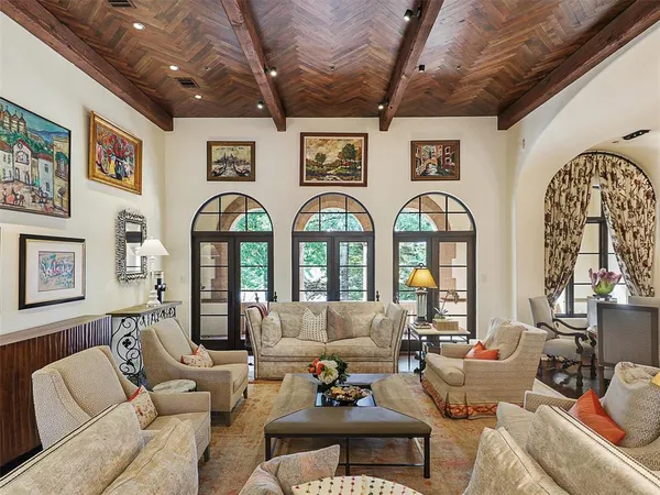a living room with furniture chandelier and a large window
