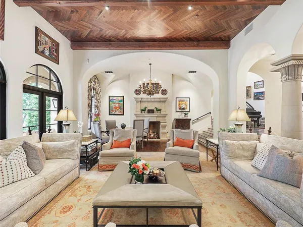 a living room with furniture chandelier and a large window