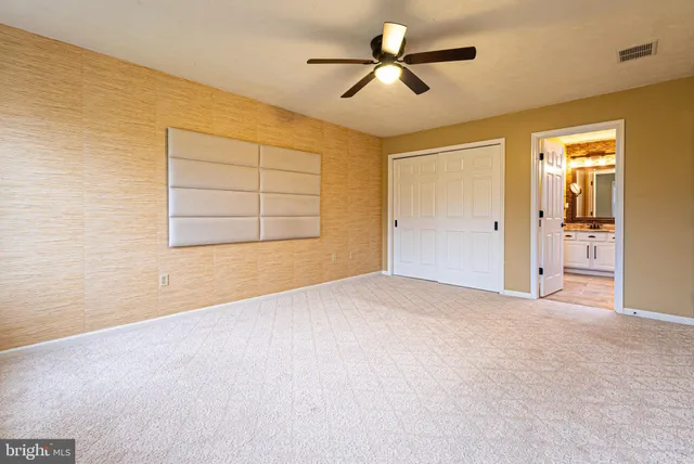 an empty room with a ceiling fan and a window