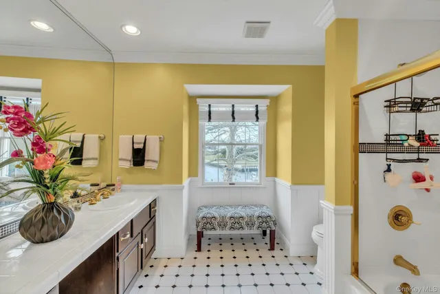 a bathroom with a tub shower sink and a window