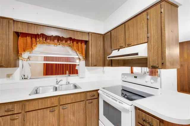 a view of a kitchen with refrigerator and cabinets