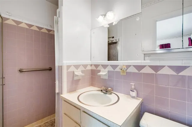 a bathroom with a sink toilet vanity and shower
