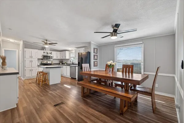 a kitchen with kitchen island white cabinets and stainless steel appliances