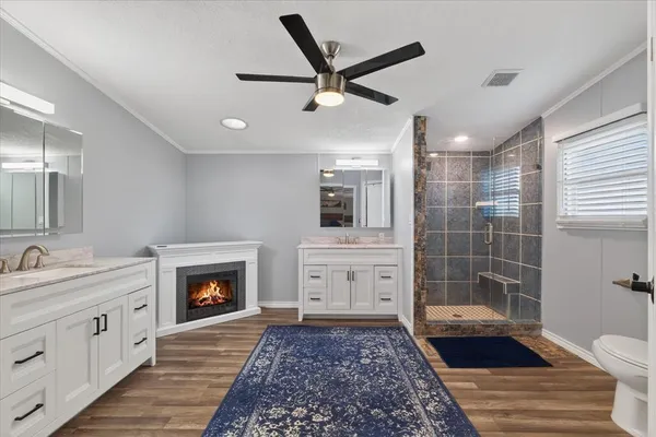 a bathroom with a sink a toilet a mirror and shower