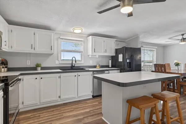 a kitchen with a sink cabinets and wooden floor