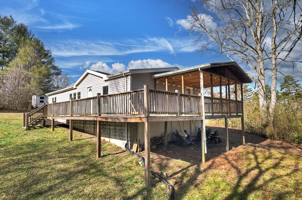 a view of a house with a wooden fence and a big yard
