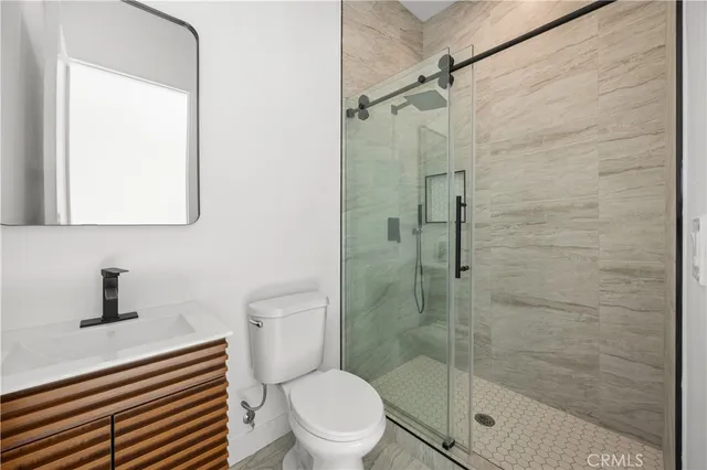 a bathroom with a shower a toilet and a sink