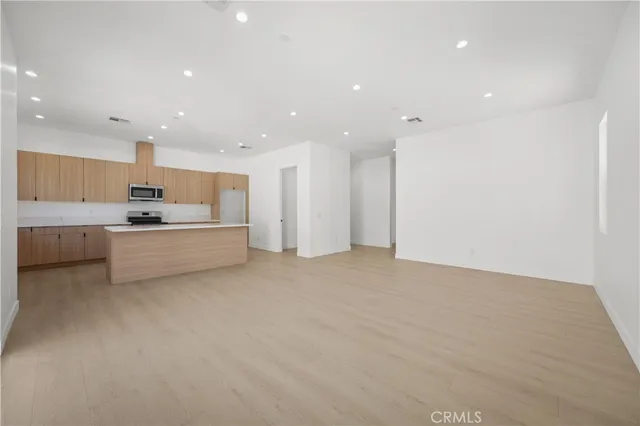 a view of kitchen with kitchen island and stainless steel appliances