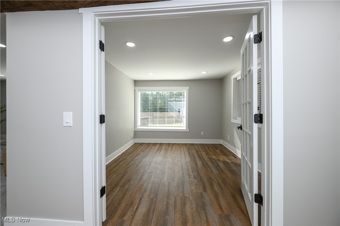 Spare room featuring dark wood-type flooring