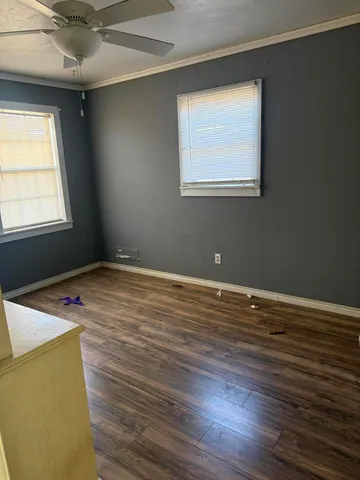 a view of a room with wooden floor and a window