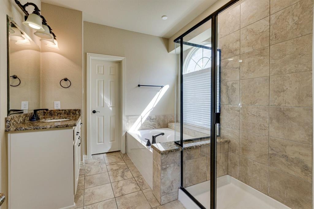 1522 Blue Jay Road Garland, TX 75043 - Photo 19 of 32 Bathroom featuring a built-in tub, separate glass-enclosed shower, tiled flooring, and a vanity with a countertop and integrated sink