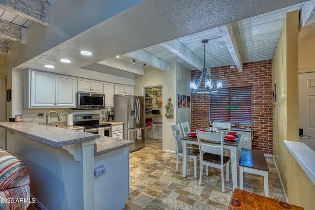 a kitchen with stainless steel appliances granite countertop a refrigerator a stove a sink and a microwave