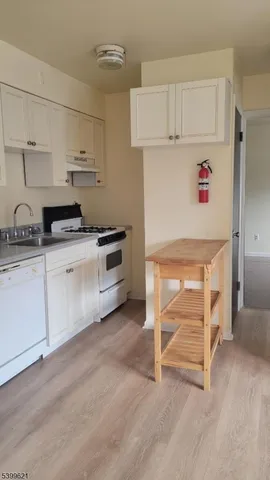 a kitchen with white cabinets and white appliances