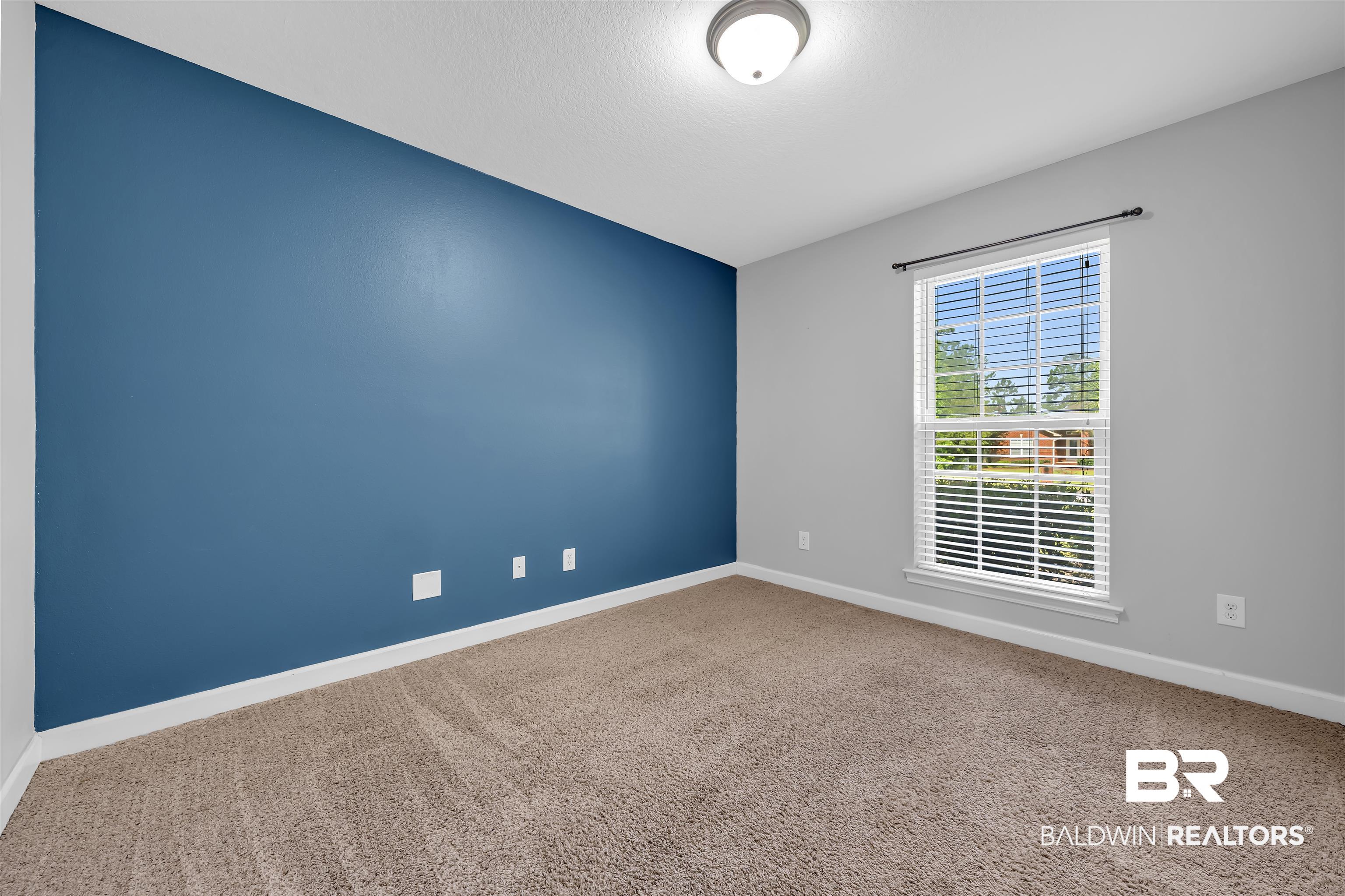 10147 Lyttleton Loop Lillian, AL 36549 - Photo 29 of 29 Room featuring a contrasting accent wall, neutral carpeting, and white trim