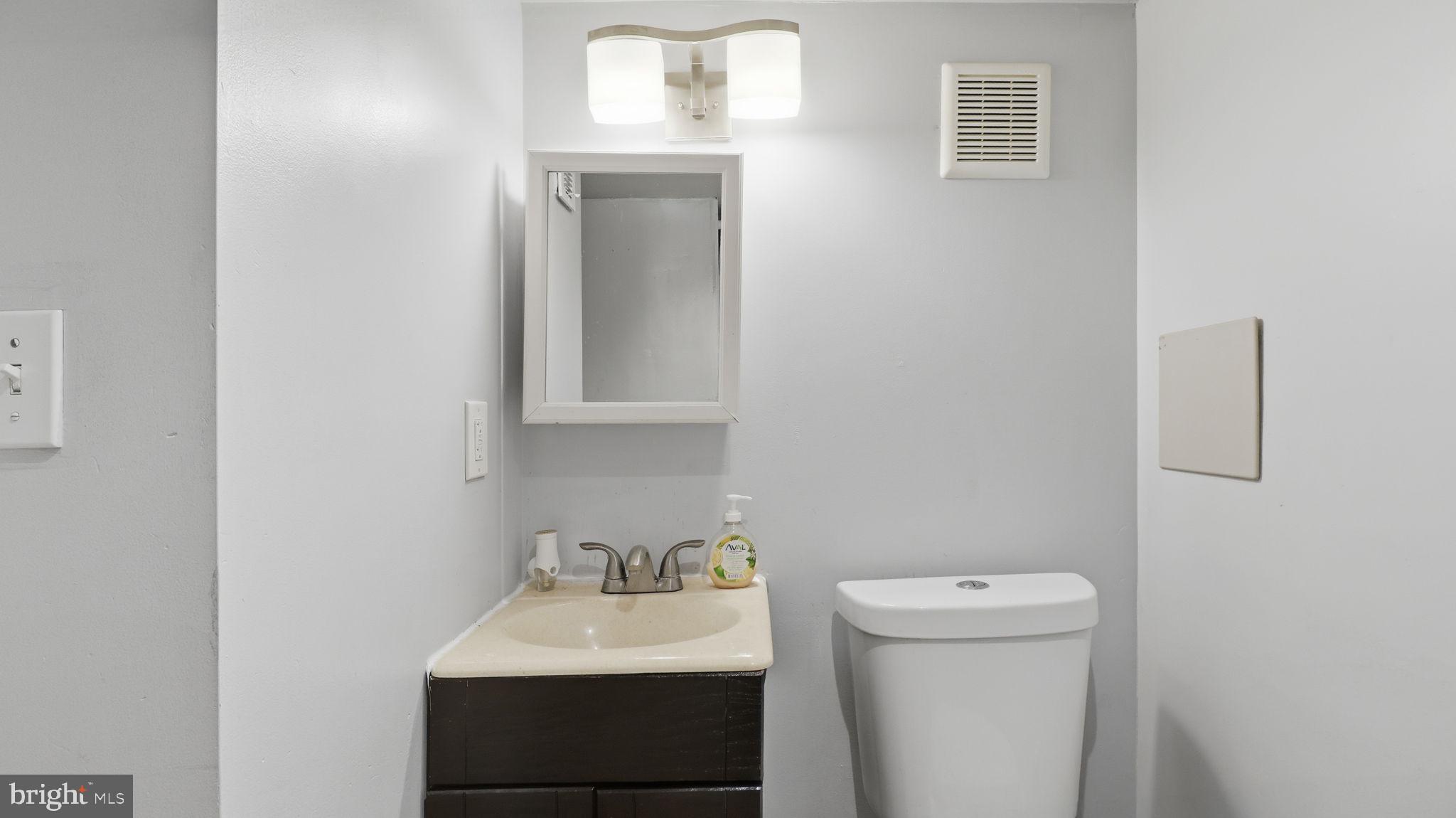 211 Fagley Street Baltimore, MD 21224 - Photo 15 of 16 a bathroom with a toilet sink and mirror