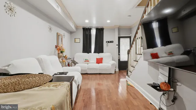 a living room with furniture and a wooden floor