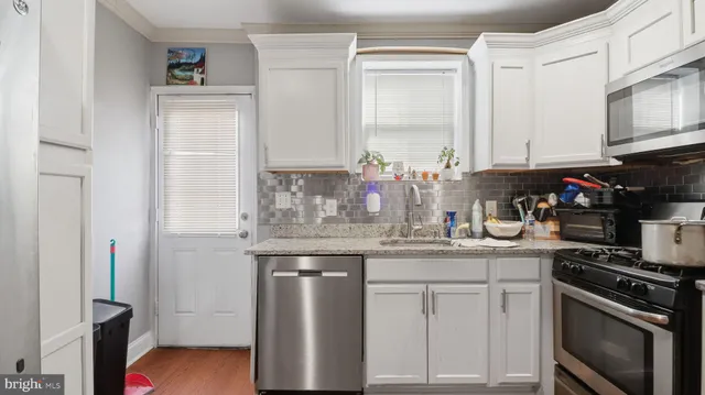 a kitchen with stainless steel appliances granite countertop a sink dishwasher stove and cabinets