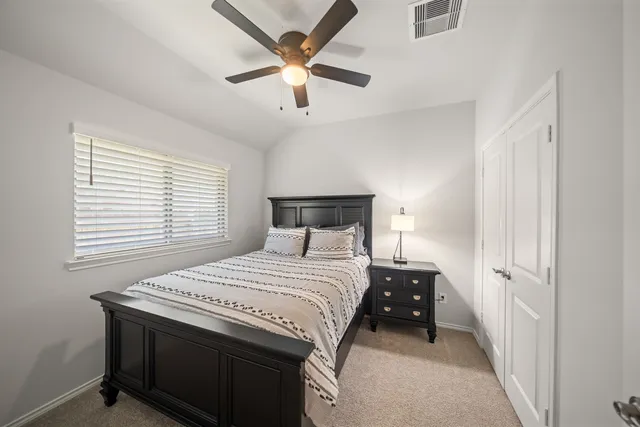 a bedroom with a bed and a large window with a projector