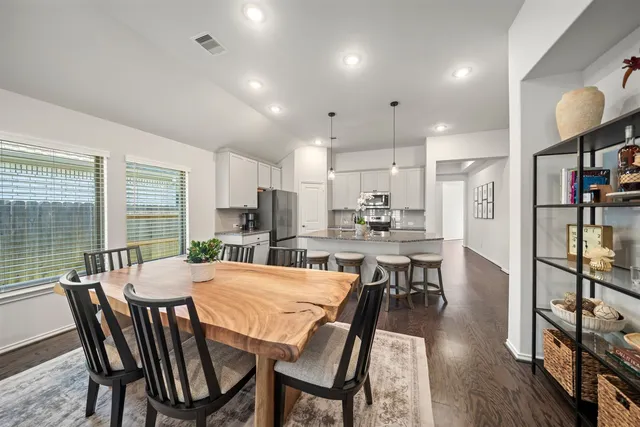 a dining room with furniture and a wooden floor