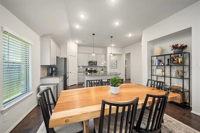 a view of a dining room with furniture a rug and wooden floor