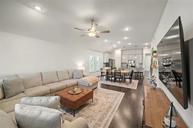 a living room with furniture kitchen view and a large window