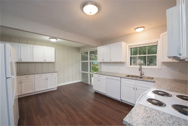 a kitchen with a sink a window and cabinets