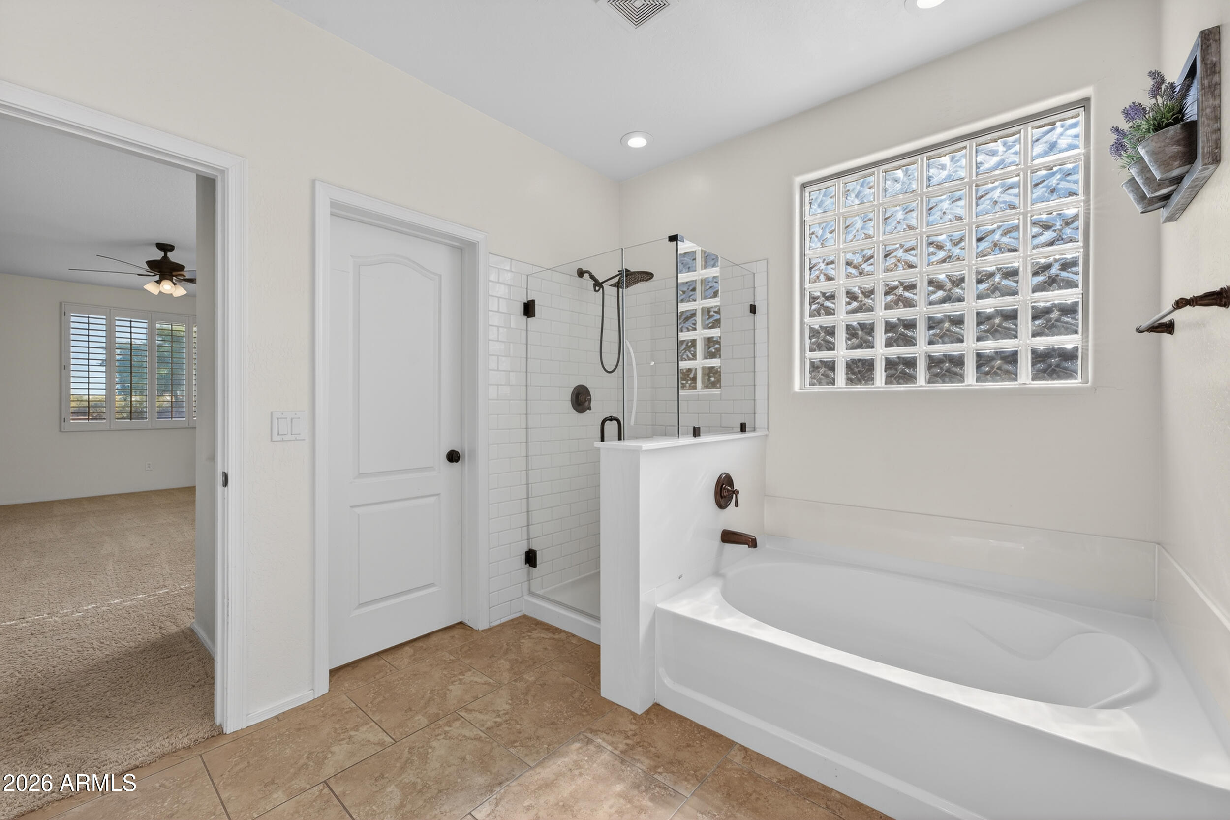 4199 North 154th Drive Goodyear, AZ 85395 - Photo 11 of 17 a bathroom with a bathtub and a shower