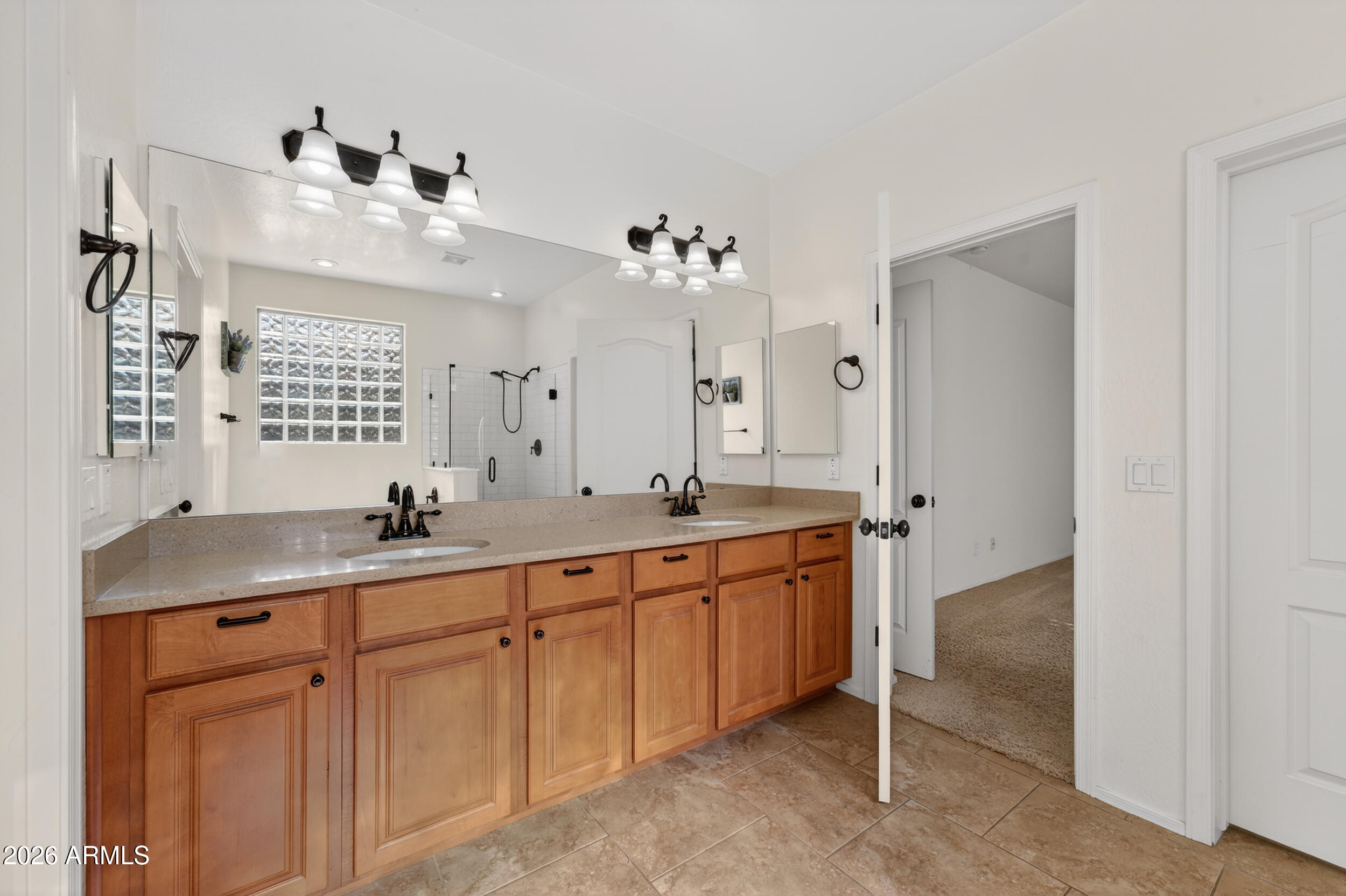4199 North 154th Drive Goodyear, AZ 85395 - Photo 12 of 17 a spacious bathroom with a granite countertop sink a mirror and a