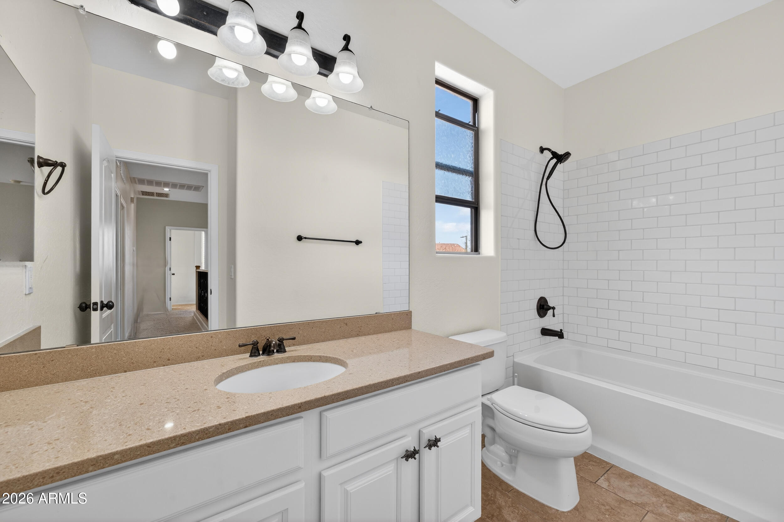4199 North 154th Drive Goodyear, AZ 85395 - Photo 13 of 17 a bathroom with a granite countertop sink a toilet and a bathtub